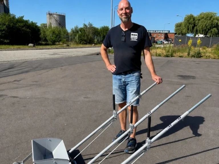 RME employee standing beside a thermoplastic hand applicator with screed box and handle frame